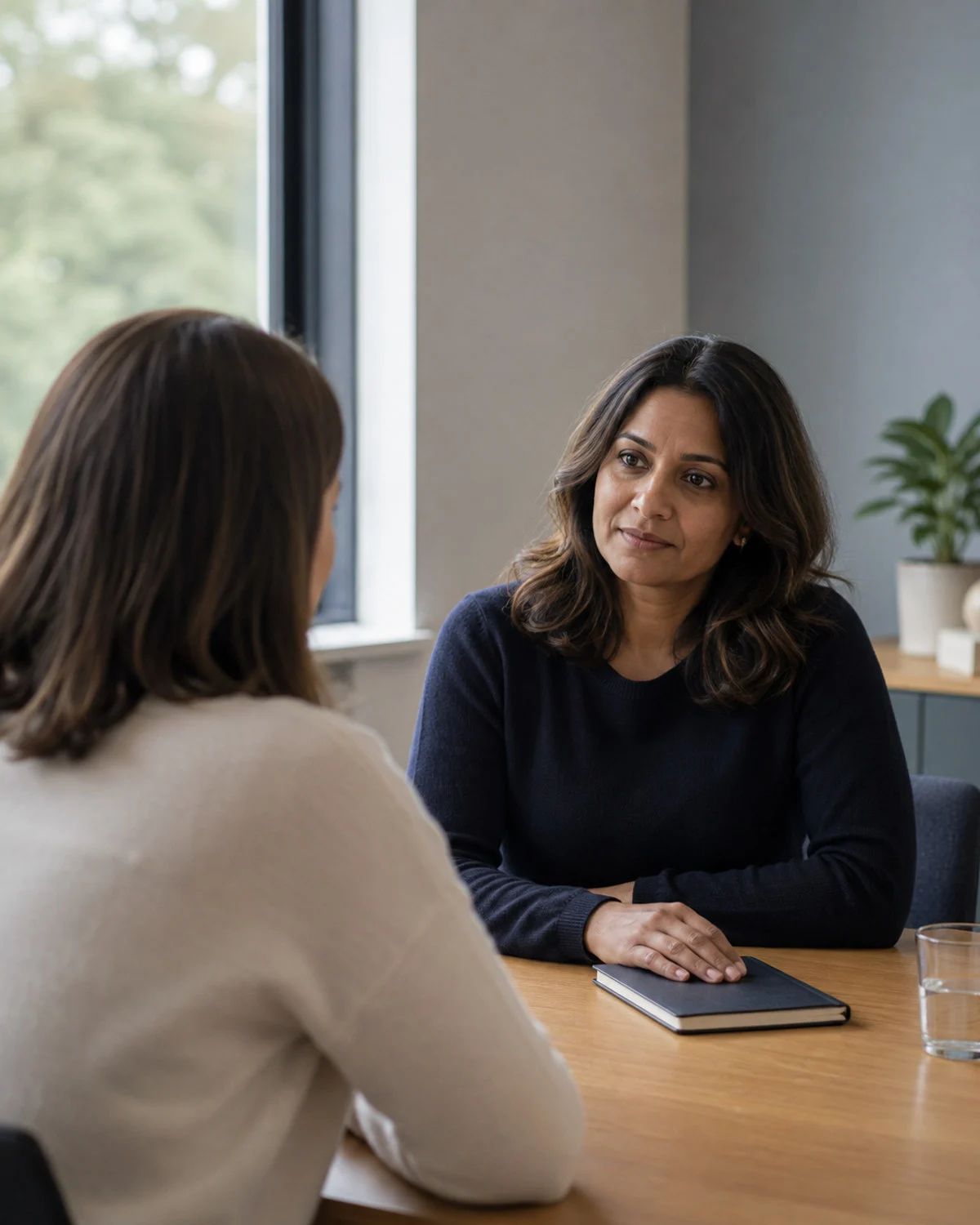 An experienced HR adviser listening carefully during a private employee-relations conversation.