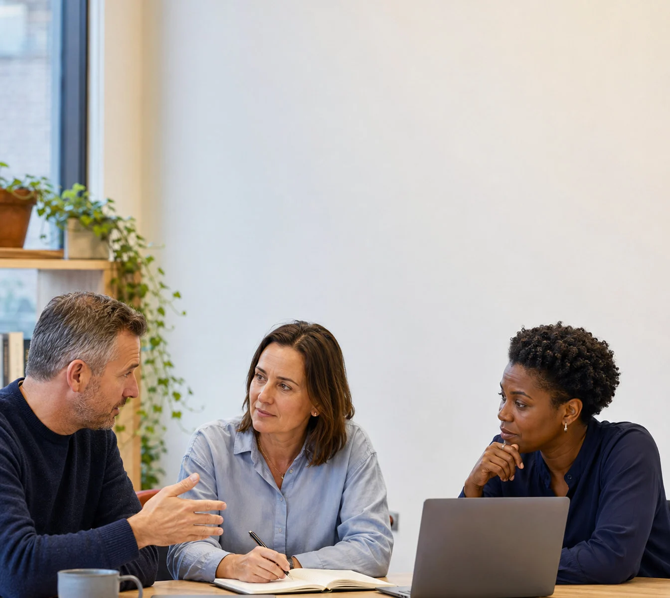 An HR partner and two leaders working through priorities during a regular check-in.